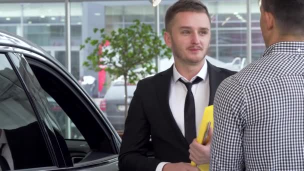 Έμπορος αυτοκινήτων χειραψία με αρσενικό πελατών μετά την πώληση ενός αυτοκινήτου - Πλάνα, βίντεο