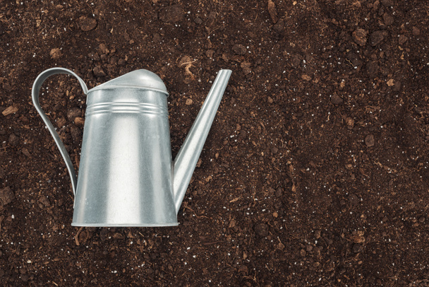 top view of watering can on ground, protecting nature concept  - Photo, Image