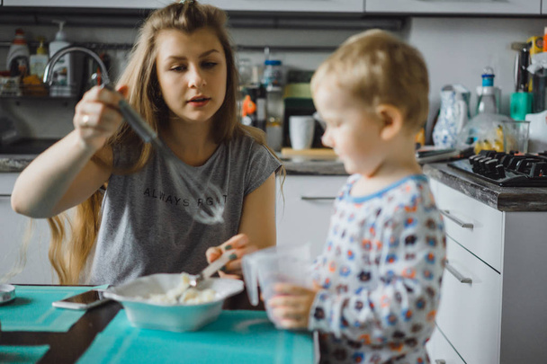 朝のパジャマの男の子と台所でアップルパイを調理しおもちゃで遊ぶ - 写真・画像