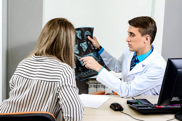 The male doctor consults the female patient on the basis of x-rays. Conceptual communication - Foto, Imagem