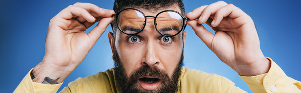 Schockierter bärtiger Mann mit blauer Brille - Foto, Bild