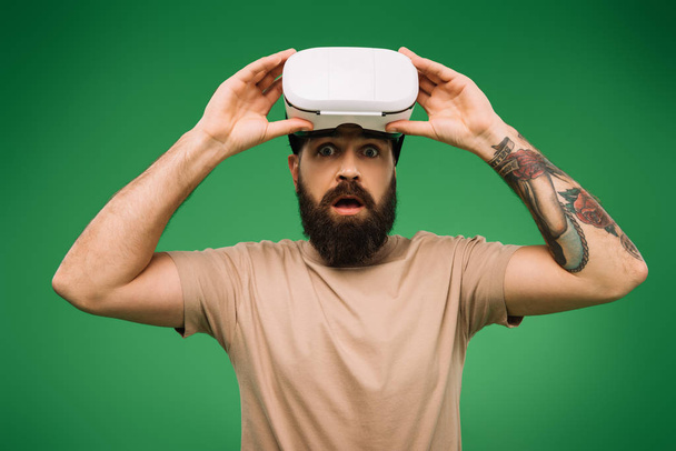 shocked bearded man with Virtual reality headset isolated on green - Photo, Image
