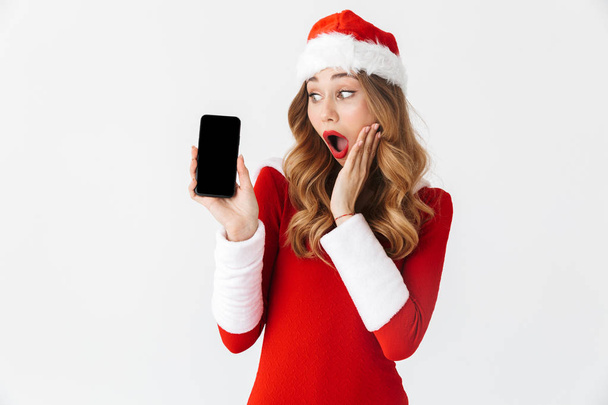 Photo of a shocked emotional woman in christmas costume showing display of mobile phone. - Fotoğraf, Görsel