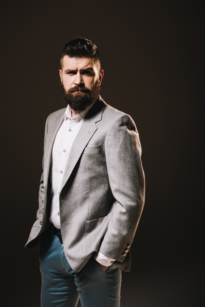 гарна борода бізнесмен позує в офіційному одязі ізольовано на коричневому
 - Фото, зображення