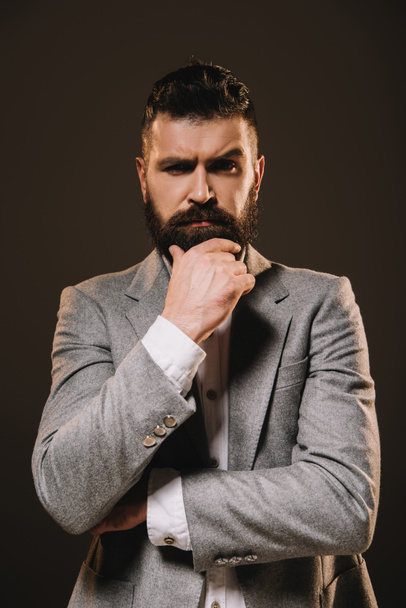 handsome beard businessman thinking and looking at camera isolated on brown - Foto, Imagem