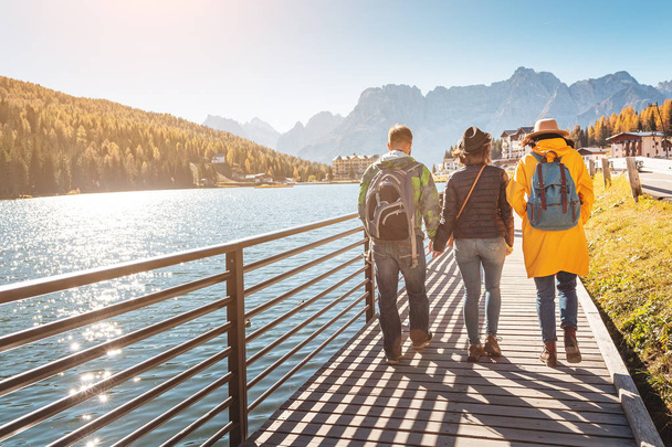 Happy tři přátelé cestují v italské Dolomity pohoří stading na pobřeží jezera Misurina - Fotografie, Obrázek