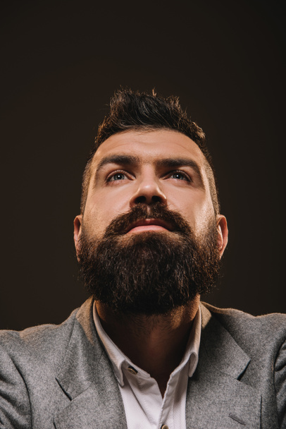 handsome beard thoughtful businessman isolated on brown - Фото, зображення