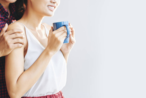 Smiling young woman with big cup of tea or coffee - Photo, Image
