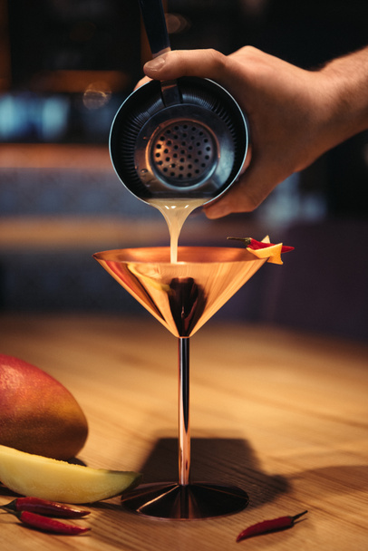 focus selettivo del barista versando cocktail dallo shaker al setaccio in vetro metallico
  - Foto, immagini