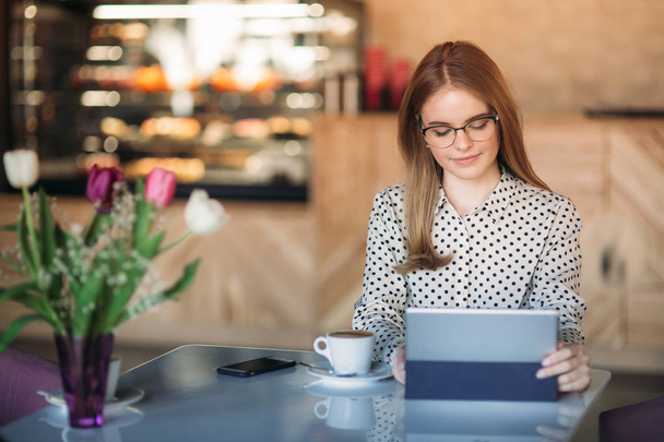 Бизнес-женщина с ноутбуком и телефоном в кафе
 - Фото, изображение