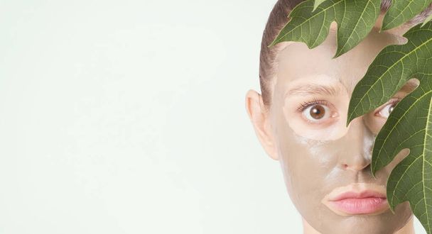 junge Frau mit grüner Gesichtsmaske - natürlicher Wellnessbereich, Schönheit aus Naturkonzept - Foto, Bild
