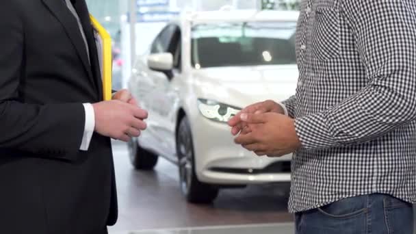 Distribuidor de coches estrechando la mano con el cliente y pasar las llaves del coche al hombre
 - Imágenes, Vídeo