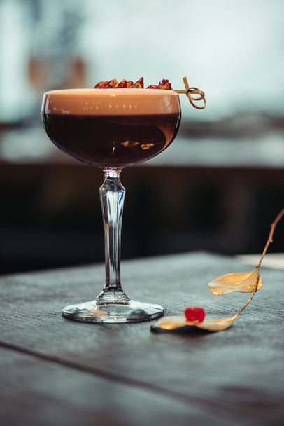 селективний фокус алкогольного коктейлю з піною і сухими квітами на темному фоні
 - Фото, зображення
