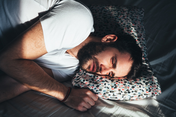 Yatakta ağlayan genç depresif adam - Fotoğraf, Görsel