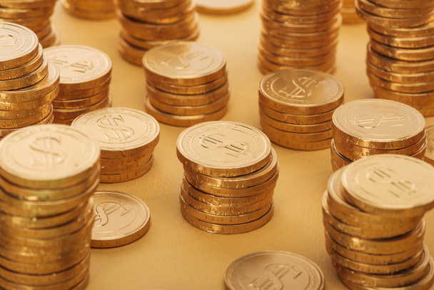 stapels van gouden munten met dollartekens geïsoleerd op oranje, st patrick dag concept - Foto, afbeelding
