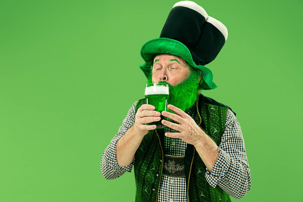 A man in a leprechaun hat at studio. He celebrates St. Patricks Day. - Foto, afbeelding