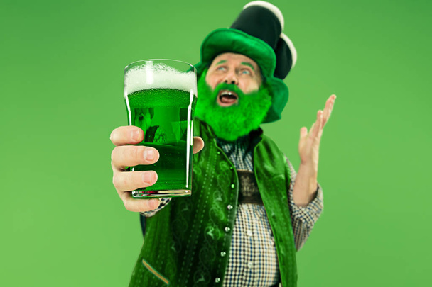 A man in a leprechaun hat at studio. He celebrates St. Patricks Day. - Fotó, kép