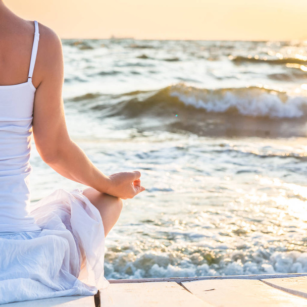 Kobieta medytująca nad morzem - Zdjęcie, obraz
