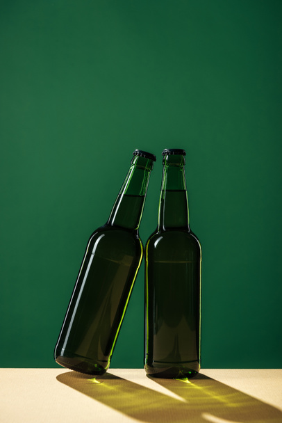 beer bottles isolated on green, st patrick day concept - 写真・画像