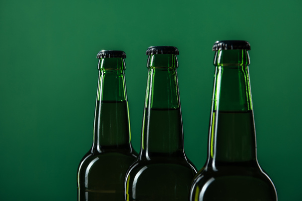 close up of beer bottles isolated on green, st patrick day concept - Foto, immagini