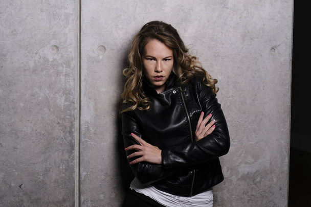 A stunning playful blonde model in a leather jacket - Foto, afbeelding