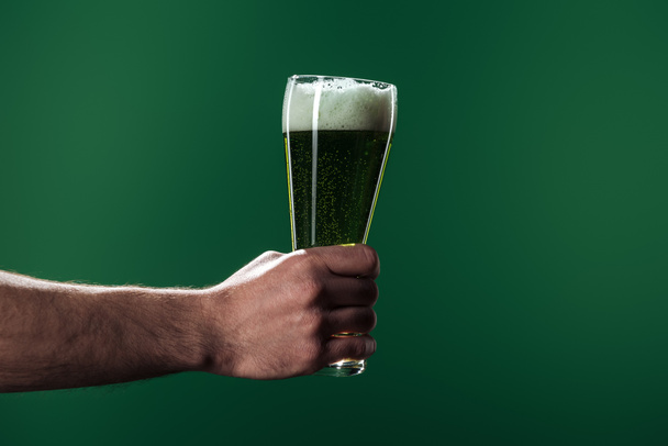 częściowy widok mężczyzny trzymającego szklanki piwa z pianki na białym tle na zielono, st patrick dzień koncepcji - Zdjęcie, obraz