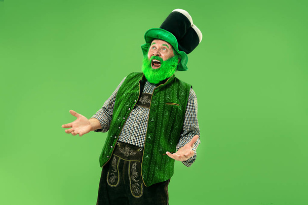 A man in a leprechaun hat at studio. He celebrates St. Patricks Day. - Фото, изображение