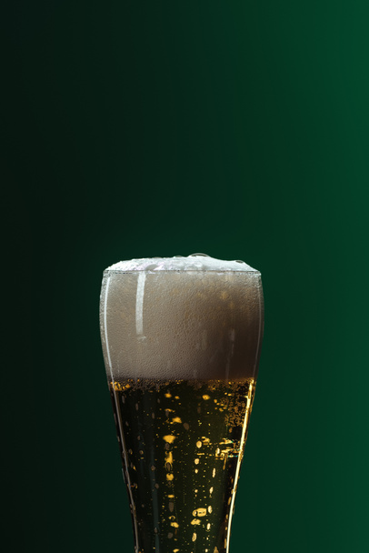 beer glass with foam and copy space isolated on green, st patrick day concept - Фото, изображение