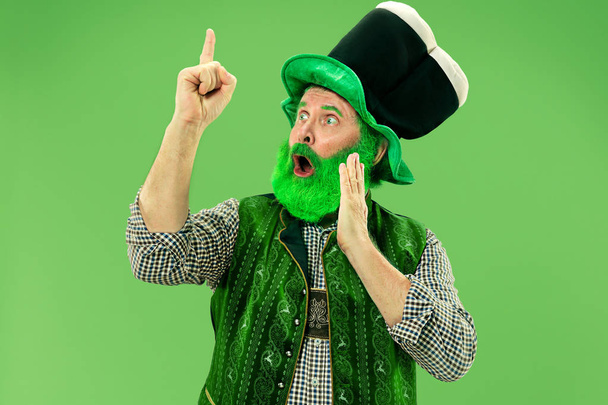 A man in a leprechaun hat at studio. He celebrates St. Patricks Day. - Zdjęcie, obraz