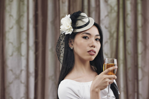Привлекательная молодая азиатка в маленькой шляпе и вуали для костюмированной вечеринки
 - Фото, изображение