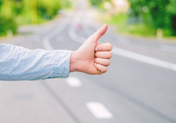 Thumb up gesture try stop car road background. Hand gesture hitchhiking. Make sure you know right gestures to stop car. Thumb up sign not work in many parts of world. Autostop travel. Pick me up - Foto, immagini