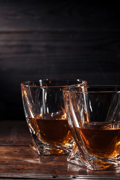 vista de cerca de dos vasos de whisky sobre una mesa de madera oscura
 - Foto, Imagen