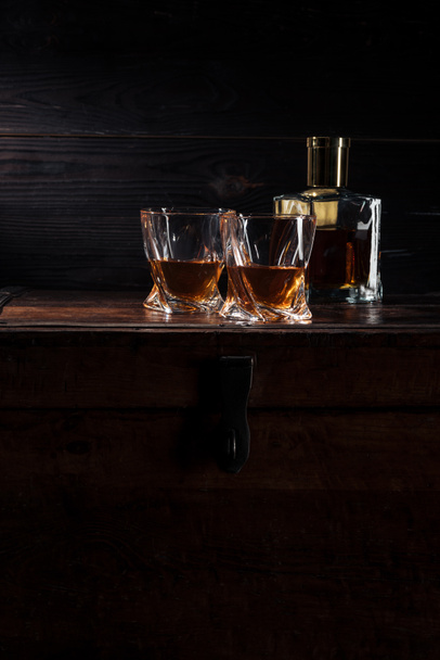 bottle and glasses of whiskey on vintage wooden table   - Foto, imagen