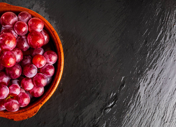 Bel primo piano di grappolo di uva rossa (inchiostri) sul tavolo. Gocce fresche, crude e d'acqua. - Foto, immagini