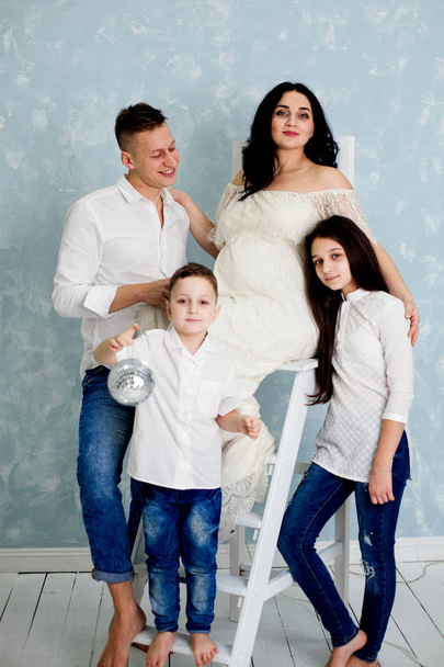 happy family with pregnant woman and children posing in the studio - Foto, Imagem