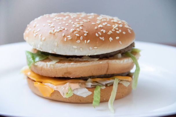Una hamburguesa grande. Restaurante de comida rápida. Comida equivocada. Colesterol y obesidad
 - Foto, imagen