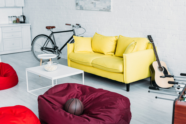 przestronny umeblowany salon z beanbag krzesła, sofa i stolik - Zdjęcie, obraz