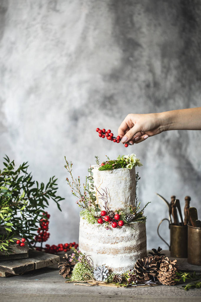 Female hand decorating wedding cake with berries - Foto, Imagem