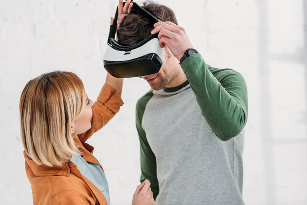 junges Mädchen hilft Freundin, Virtual-Reality-Headset aufzusetzen - Foto, Bild