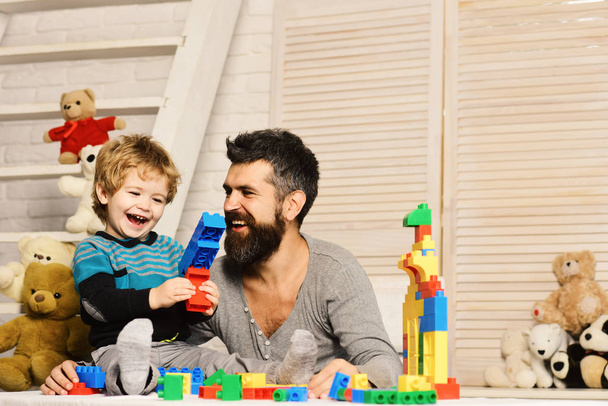 Boy and bearded man play together on wooden wall background - Foto, immagini