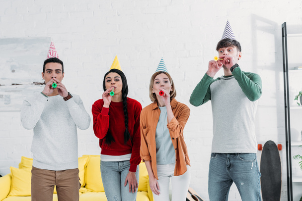 multiethnic friends in multicolored paper hats having fun at home party - Фото, зображення