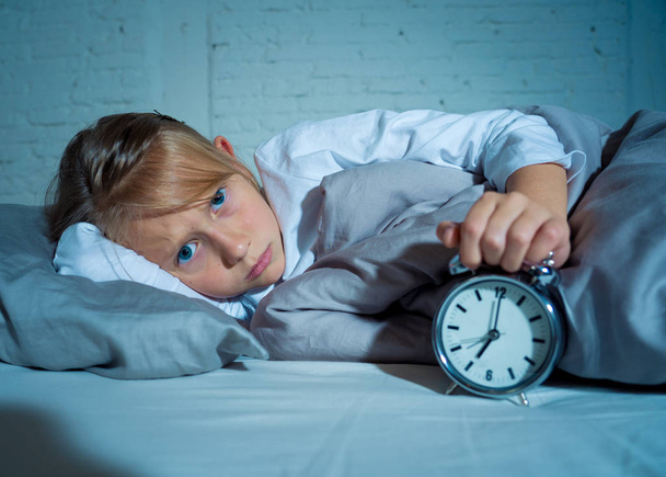 Bezesných malá holčička ležící smutný v posteli a díval se na budík, museli probudit, ale pocit únavy na potíže zůstat spánku poruchy spánku noční děsy a děti nespavost koncepce. - Fotografie, Obrázek