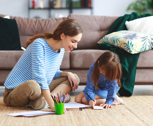 щаслива любляча сім'я мати і дитина дочка малює вдома
 - Фото, зображення