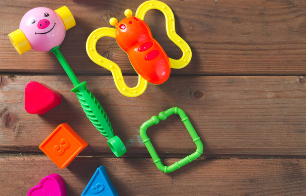 Top view or flat lay on colorful toys on dark wooden background with copy space. Warm vintage filter - Photo, Image