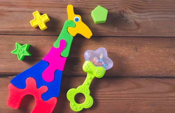 Top view or flat lay on colorful toys on dark wooden background with copy space. Warm vintage filter - 写真・画像