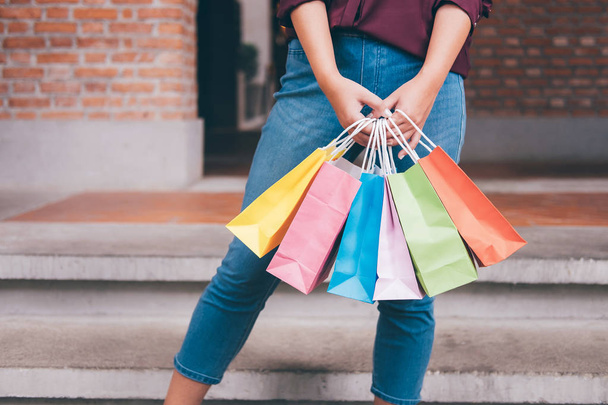 消費者と幸せな若い女立って押し続けるカラフルなショッピング バッグ買い物中で素晴らしい一日を楽しむショッピング ライフ スタイル コンセプト. - 写真・画像
