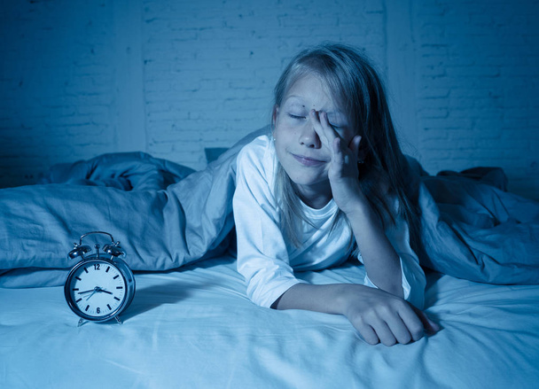 Cute sleepless little girl lying in bed looking sad and tired having sleeping troubles staying asleep at night or waking too early in the morning in Insomnia Anxiety Sleep Disorders in children. - Foto, immagini