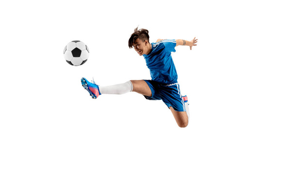 Young boy with soccer ball doing flying kick - Fotó, kép