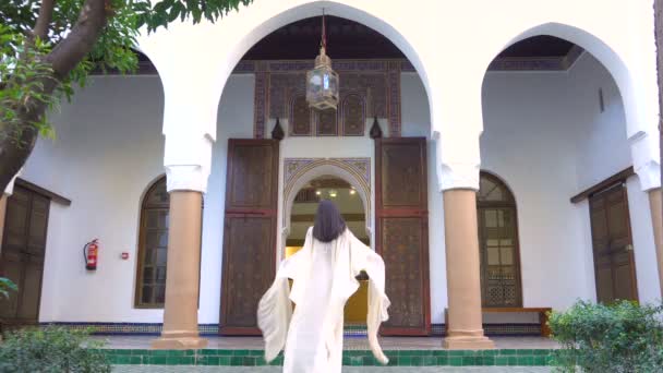 schöne marokkanische Mädchen schwenkt ihren weißen Mantel in malerischen dar si sagte Riad in Marrakesch bei Sonnenuntergang - Filmmaterial, Video