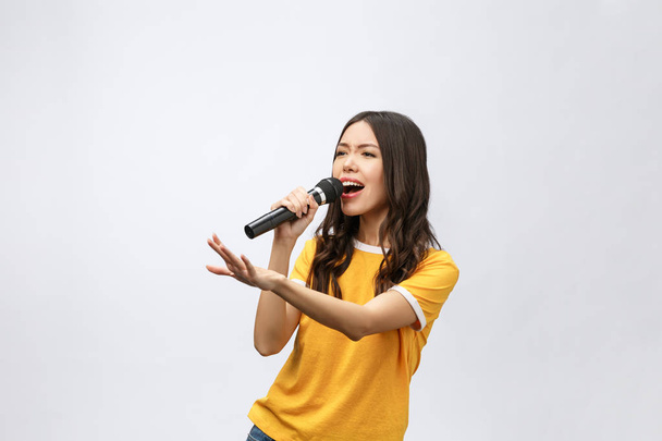 schöne stilvolle Frau singt Karaoke isoliert über weißem Hintergrund. - Foto, Bild